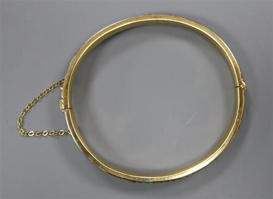 A gilt white metal and twin row red stone set hinged bracelet, with safety chain, gross 22.1 grams.